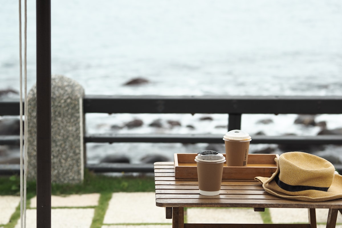 Two coffees on a seaside table — the calm of a handled life